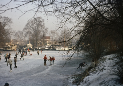 808818 Gezicht op de bevroren Leidsche Rijn te Utrecht, ter hoogte van het Park Oog in Al, met enkele schaatsers en op ...